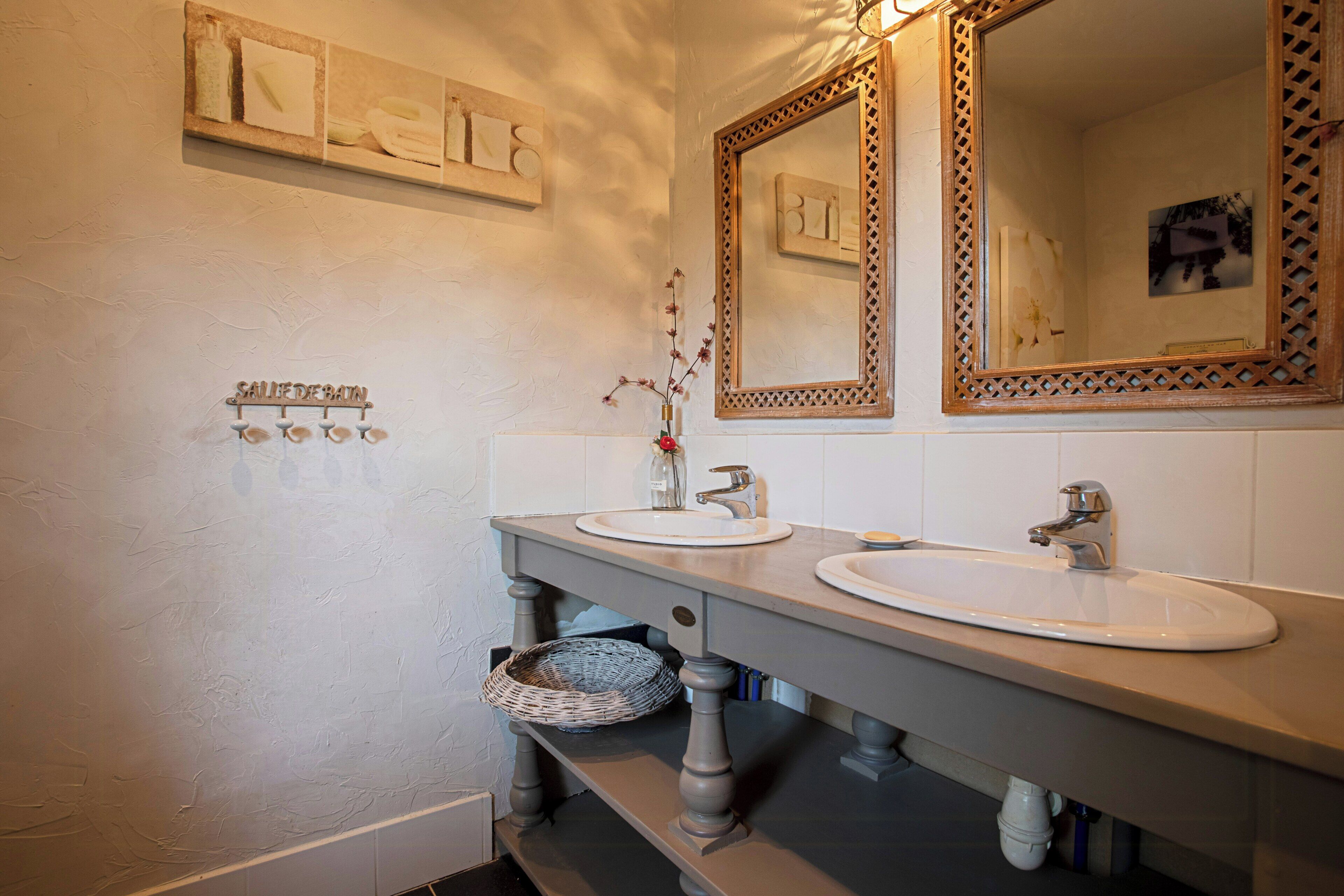 A bathroom with two sinks, a mirror, and a towel rack.