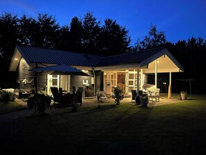 A house with a covered patio, a dining area, and a garage. - Holiday home with sauna near Anneberg (Højby)