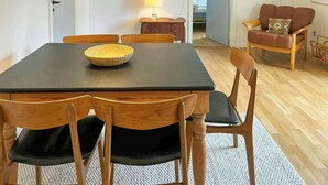 Un comedor con mesa, sillas, una lámpara y un sofá.