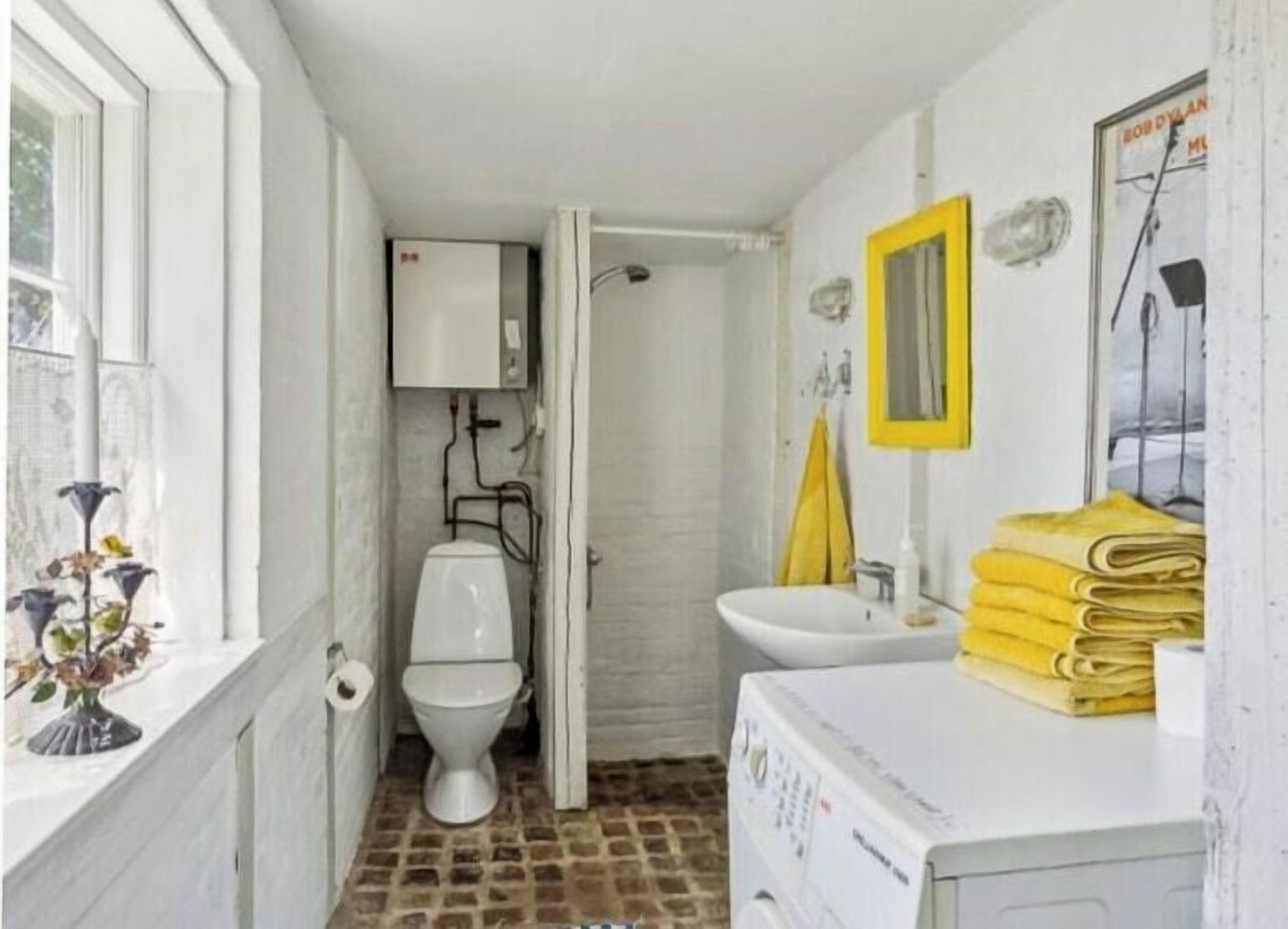 Une petite salle de bain avec des toilettes, un lavabo et une fenêtre.