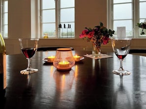 Ein Tisch mit zwei Weingläsern, einem Kerzenständer und einer Vase mit Blumen.