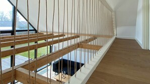 Ein modernes Interieur mit Holzboden, weißer Decke und Blick durch große Fenster.