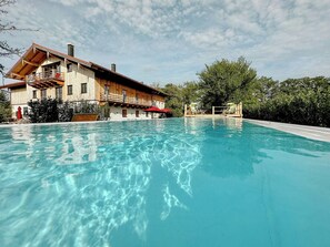 Ein Schwimmbecken mit einem Holzgebäude im Hintergrund.