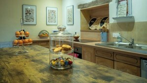Eine Küche mit Holzausstattung, einem Glas mit Keksen, einem Obstkorb und einem Spülbecken.