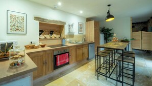 Eine moderne Küche mit Holzausstattung, einem Backofen, einer Spüle und einer Bar mit Hockern.