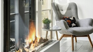 En modern inredning med en öppen spis, ett upphängt djurskalle och en bekväm fåtölj.