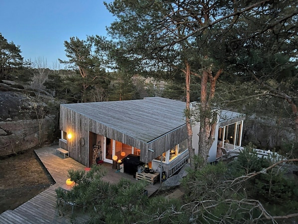 Eine Holzhütte mit einer Terrasse und einer überdachten Veranda.
