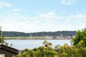 A marina with numerous sailboats docked along the shore, surrounded by greenery and a clear sky. - House with ferry views by Isefjorden (Holbæk)