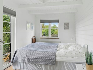 A bedroom with a bed, a window, a radiator, and a nightstand. - House with ferry views by Isefjorden (Holbæk)