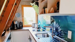 Een keuken met een spoelbak, een koffiezetapparaat en een broodrooster.