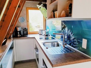 Eine Küche mit Spüle, Kaffeemaschine und Toaster.