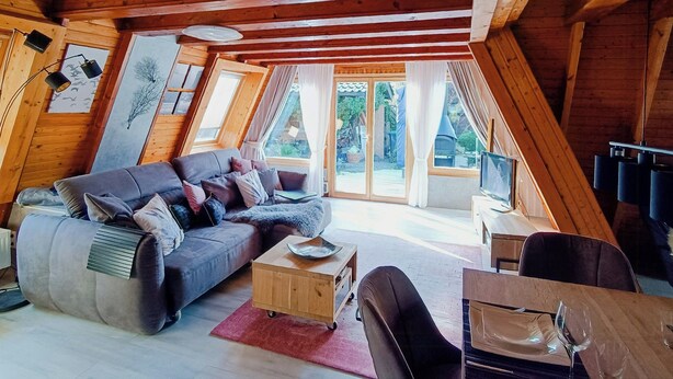 Een gezellige loft met een bank, een klein houten tafeltje en een eethoek.