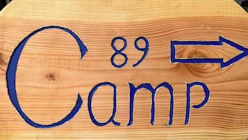 Ein hölzernes Schild mit der Nummer 89 und einem nach rechts zeigenden Pfeil, der den Weg zum Camp weist.