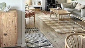 A cozy living room with a fireplace, a sofa, a coffee table, and a wooden cabinet. - House among dunes and trees in Søndervig (Ringkøbing)
