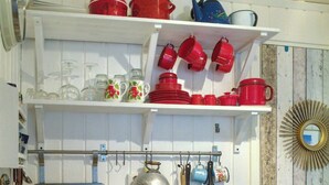 Una cocina con encimera de madera, pileta de acero inoxidable y muebles de color blanco.