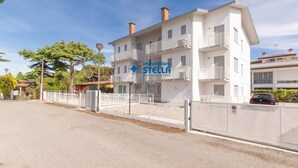 Um edifício de vários andares com fachada branca, varandas e uma placa com a inscrição 'immobiliare STELLA'.