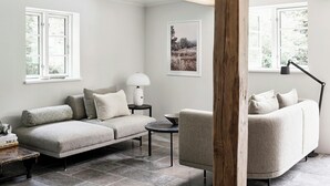 A cozy room with a sofa, a small table, a lamp, and a framed picture on the wall.