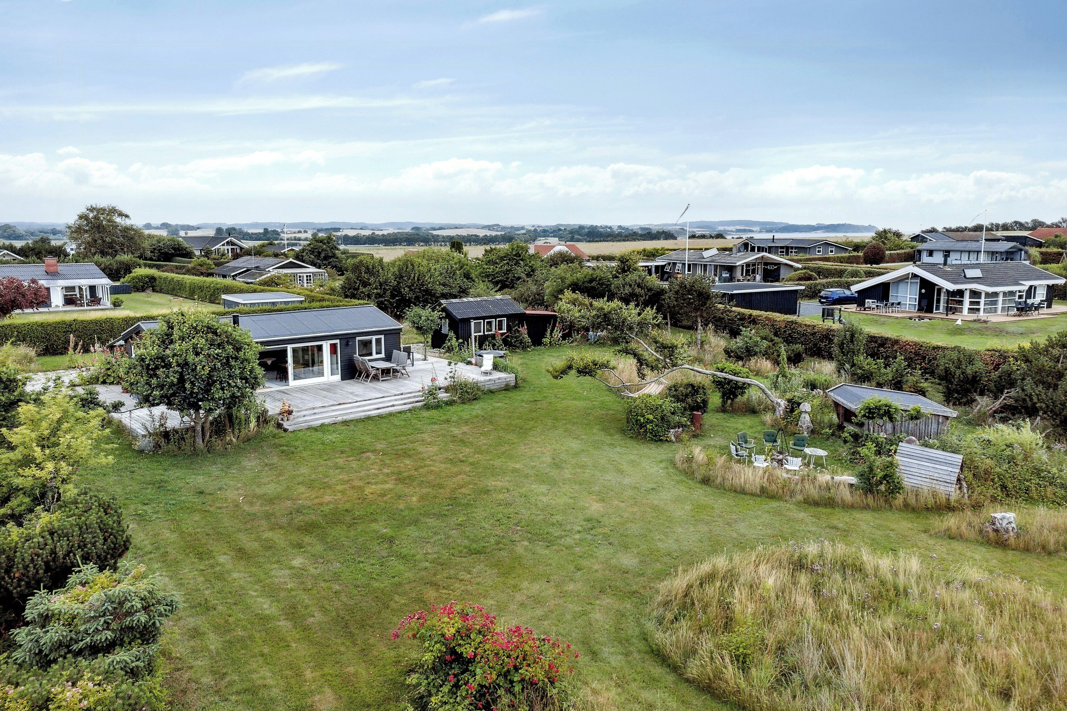 A residential area with houses, a grassy lawn, and a clear sky.