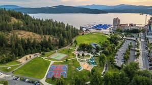 An aerial view of a park with basketball courts, a playground, and a parking area.