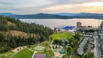 An aerial view of a park with basketball courts, a playground, and a parking area.