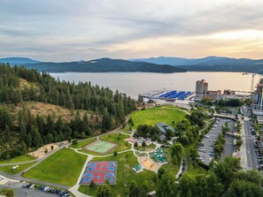 Vue aérienne d’un parc comprenant des terrains de basketball, une aire de jeux et un parking.