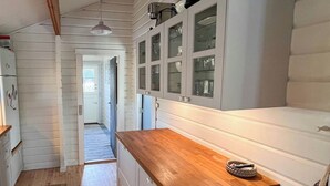 Uma cozinha com armários de madeira, bancada de madeira e uma geladeira.