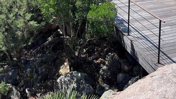 Un resort con piscina, sillones de descanso y montañas al fondo.