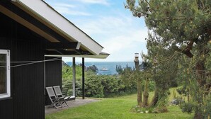 Un bâtiment doté d’un patio couvert, de deux chaises et offrant une vue sur la mer.