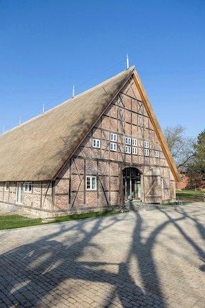 A traditional half-timbered building with a steeply pitched roof and a large entrance. - Relax in a thatched barn with a sauna (Ratekau)