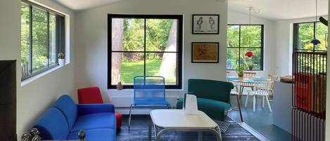 A modern interior with a blue sofa, a white table, and a green chair.