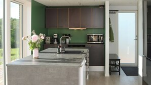 Una cocina moderna con una isla central, una cafetera y un microondas.