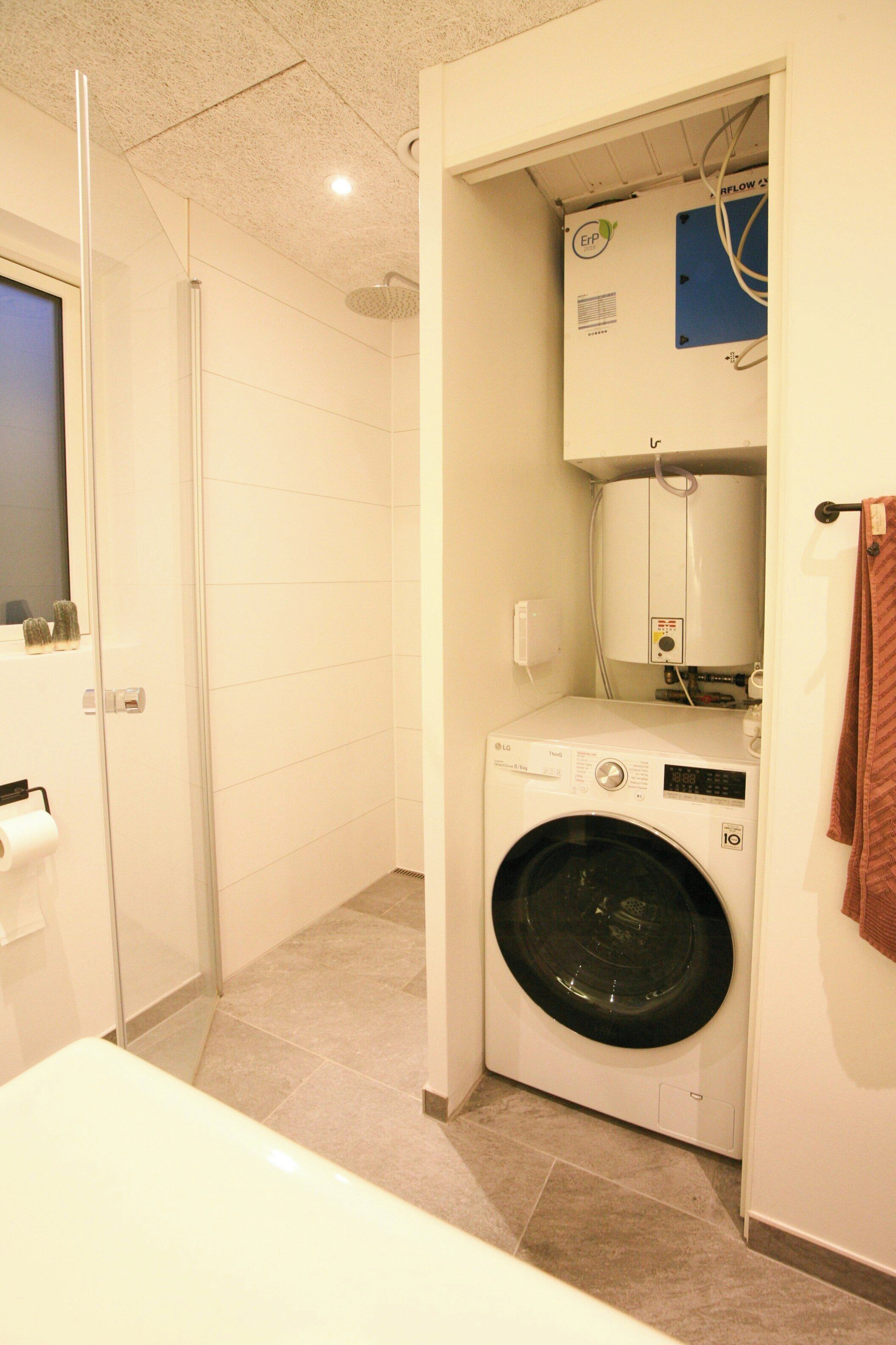 A laundry room with a washing machine, a dryer, and a water heater.