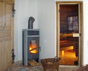 Ein Zimmer mit Kaminofen, Korbwäsche und einer Holztür.