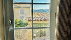 A window with a view of a building with a tiled roof and a door with a handle. - Village house with panoramic view in Venasque (Venasque)