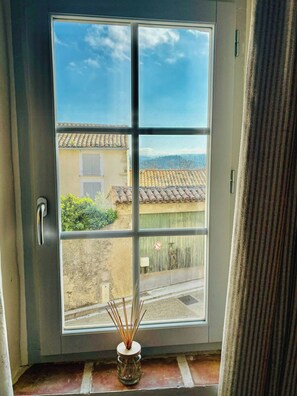 A window with a view of a building with a tiled roof and a door with a handle. - Village house with panoramic view in Venasque (Venasque)