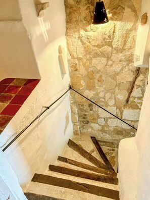 A staircase with stone walls, a red-tiled floor, and a black light fixture. - Village house with panoramic view in Venasque (Venasque)