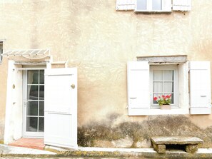 A building with a white door, a window with shutters, and a stone bench. - Village house with panoramic view in Venasque (Venasque)