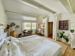 A bedroom with a large bed, a desk, a chair, a bookshelf, and a window. - Holiday home with private garden in Ugglehult (Hjärnarp)