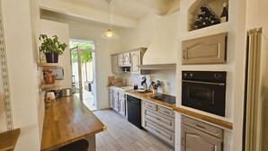 Une cuisine dotée d’un plan de travail en bois, d’appareils électroménagers intégrés et d’une plante en pot.