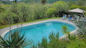 A swimming pool with lounge chairs and umbrellas, surrounded by greenery and hills. - Giglio. Country villa with private pool near Lucca (Lucca)