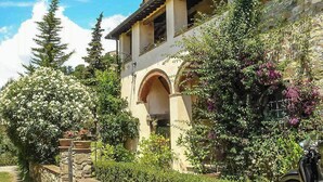 A stone building with a balcony, surrounded by lush greenery and flowering plants. - Giglio. Country villa with private pool near Lucca (Lucca)