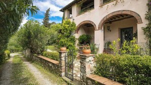 A villa with a stone pathway, arched entrance, and lush greenery. - Giglio. Country villa with private pool near Lucca (Lucca)