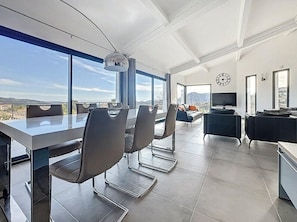 A modern conference room with a large table, chairs, and a television. - Modern villa with sea views and infinity pool (Les Adrets-de-l'Estérel)
