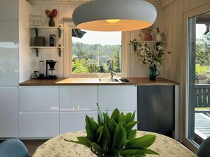 Eine moderne Küche mit Fenster, einer Spüle und einem Essbereich mit Tisch und Stühlen.