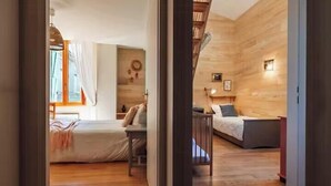 A room with a bed, a desk, and a chair, wooden walls, and a window. - Charming house in an organic wine estate (Frontignan)