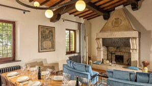 A dining area with a wooden table set for a meal, a blue sofa, and a fireplace.
