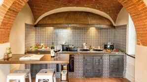 A kitchen with a brick arch, checkered backsplash, and modern appliances.
