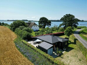 A modern house with a large roof, surrounded by a garden and a field. - Holiday home with view of Helnæs Bay (Haarby)