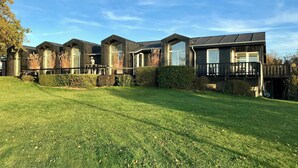 A row of modern houses with large windows and a well-maintained lawn. - Architect-designed house with private beach (Løgstrup)