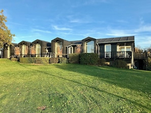 A row of modern houses with large windows and a well-maintained lawn. - Architect-designed house with private beach (Løgstrup)